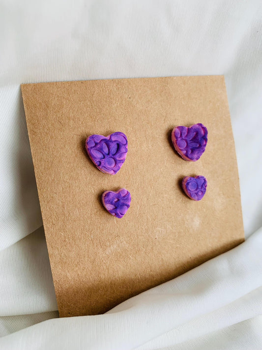 Floral pattern embossed in two sizes of stud earrings in purple colour