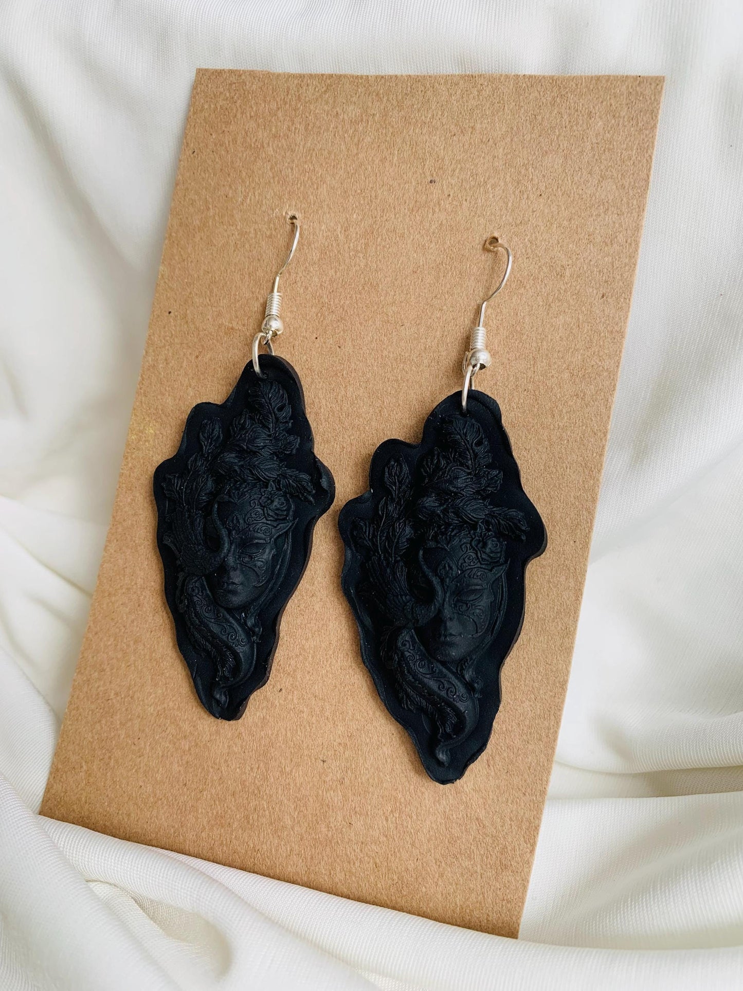 Black masquerade masked face embossed dangle earrings